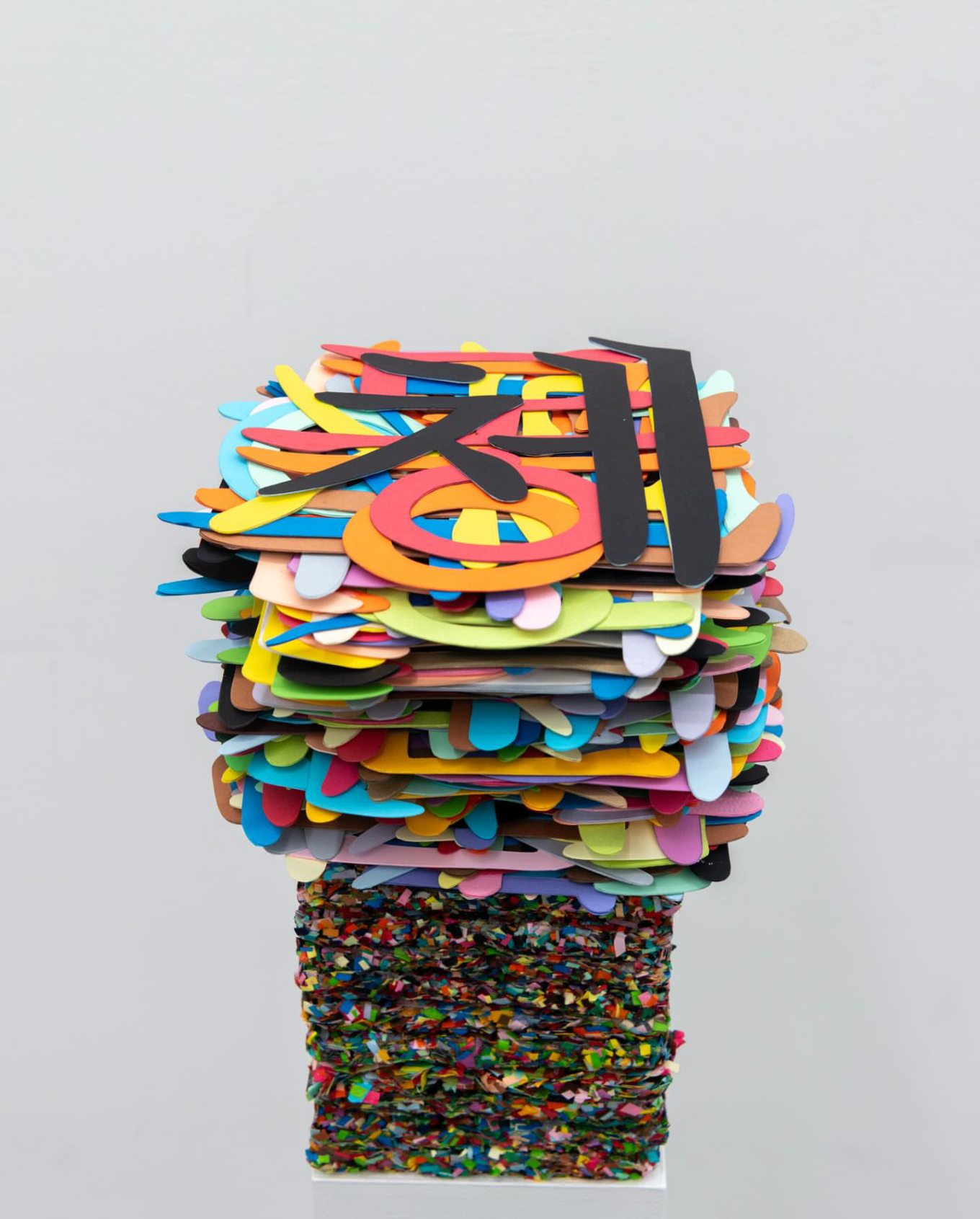 의미의 무게, 수작업으로 자른 종이, 9개 단어 20개씩, 398개, 25x21x(h)45cm, 2025 / 밖으로 꺼내지 못하고 마음에 담아두기만 했던 말을 꺼낸 작품. 내용을 읽을 수 없게 한 덩어리로 표현된 것은 여전히 남아 있는 응어리의 상태이기 때문이다. 